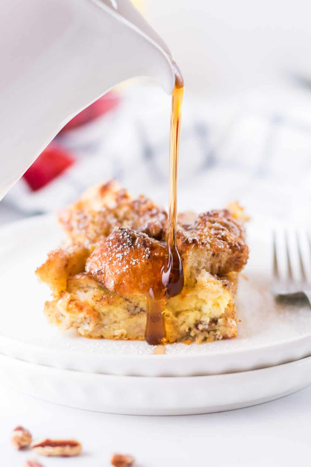 maple syrup being poured on baked french toast casserole