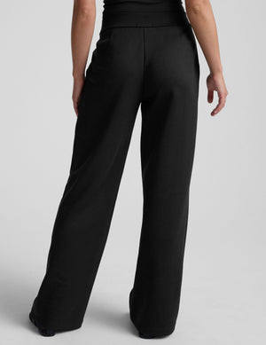 model is wearing a black sleeveless top and black spacer style pants with pockets against a plain background. 