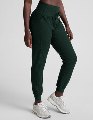 model wearing green midi length joggers with a drawcord at the waistband against a plain background. 