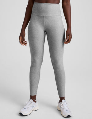 grey high-waisted midi length leggings with white piping details on sides. 